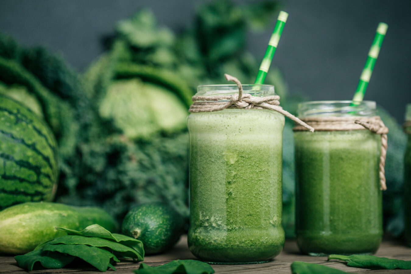 Blended green vegan smoothie on wooden table