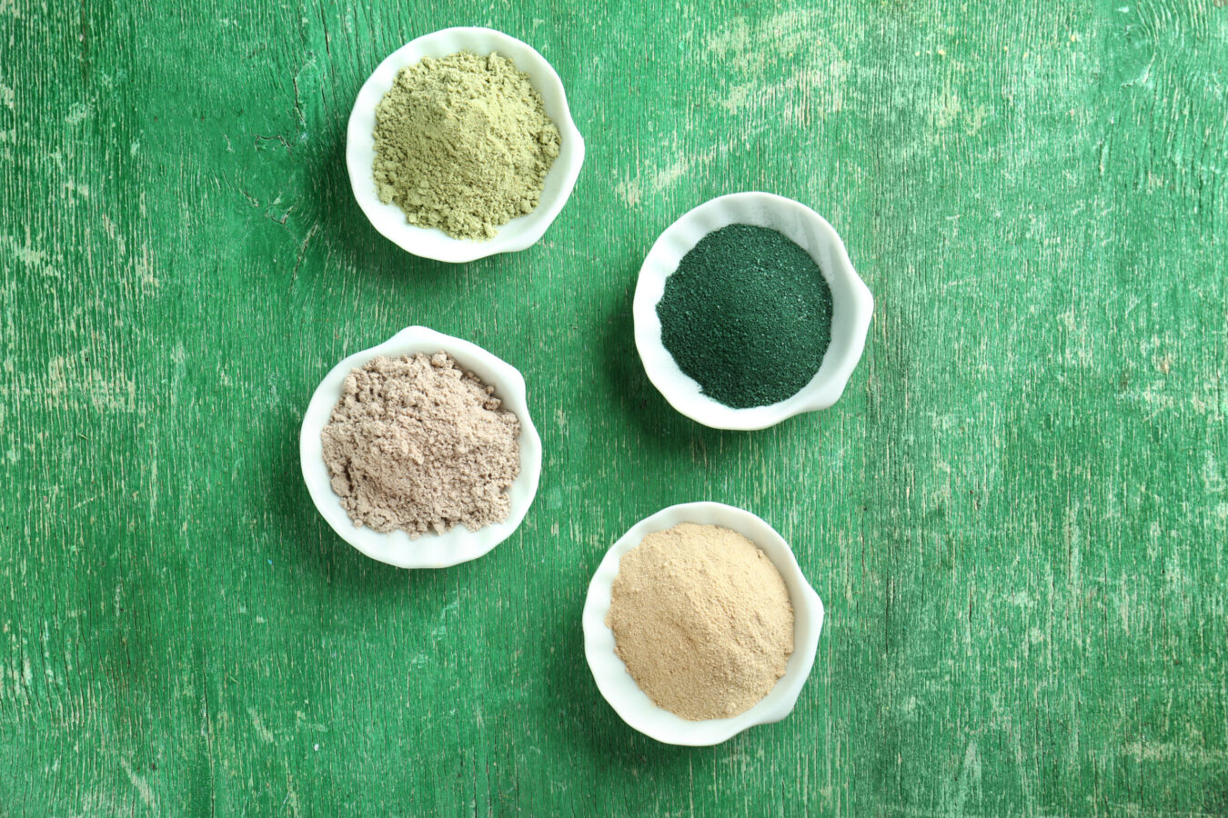 Superfood powders in bowls on wooden table vegan