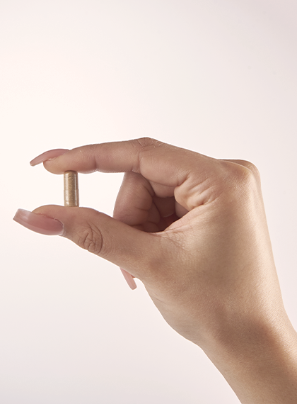 Get up and Go supplement capsule held in thumb and forefinger
